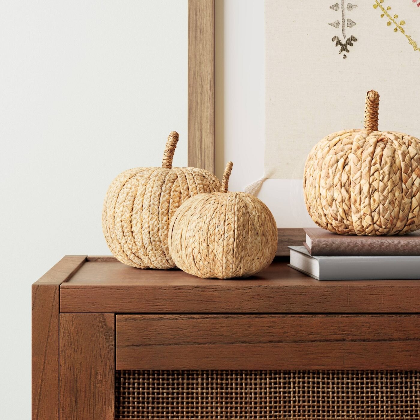 I do think that a little holiday decor is amazing and really does bring joy to all of us! I suggest focusing on things with a longer “shelf” life. Stick with these raffia pumpkins that can transition to Thanksgiving decor instead of a black and oran…