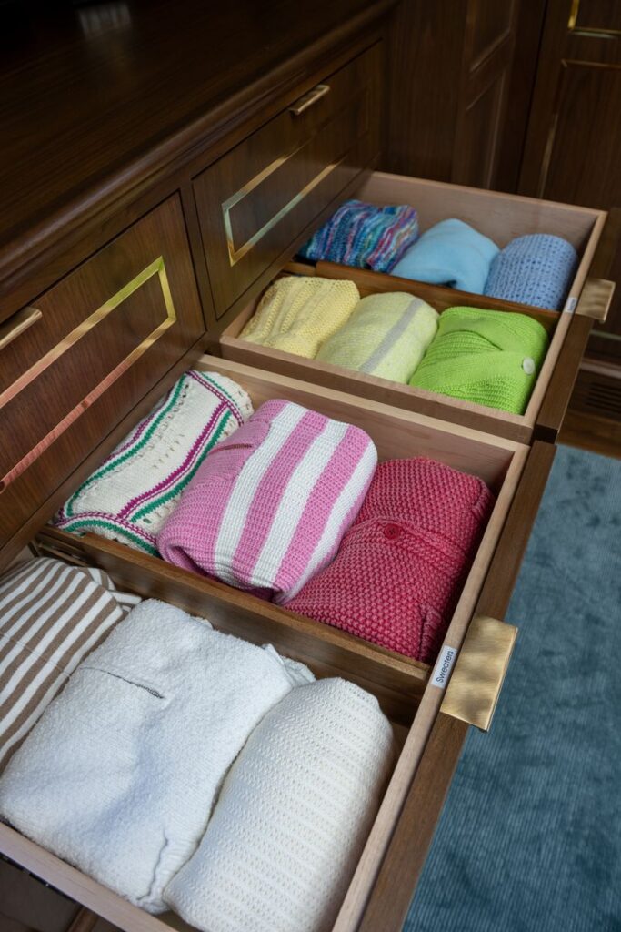 Best sweater organization tips for fall with neatly folded sweaters by color